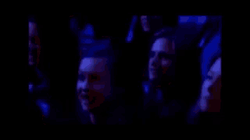 a group of people are laughing together in a dark room .