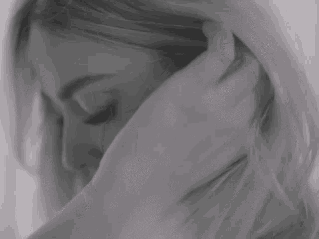a close up of a woman covering her face with her hands