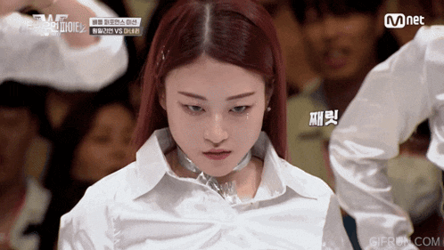 a woman in a white shirt with a choker around her neck is on a mnet video