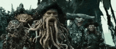 a group of pirates of the caribbean characters standing next to each other .
