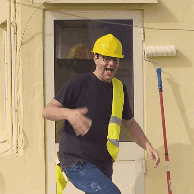 a man wearing a hard hat and a yellow vest is dancing