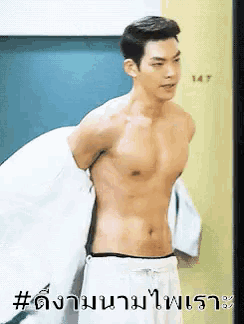 a shirtless man is standing in a room with the number 147 on the wall