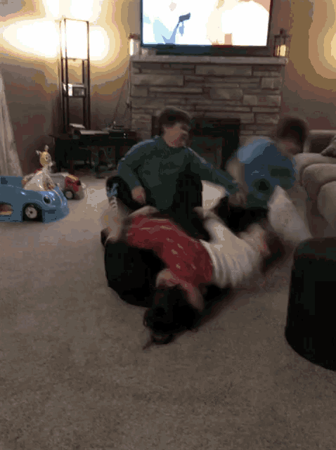three children are playing on the floor in front of a tv