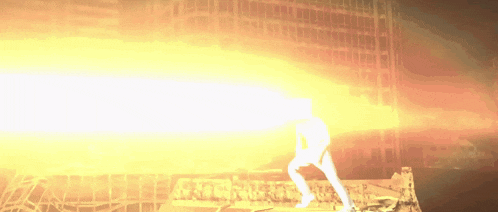 a person is standing in front of a building with graffiti on it and a fire coming out of it