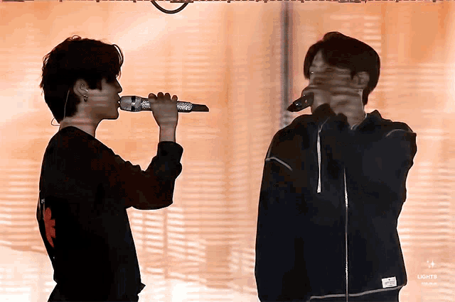 a man singing into a microphone next to another man with the words lights on the bottom