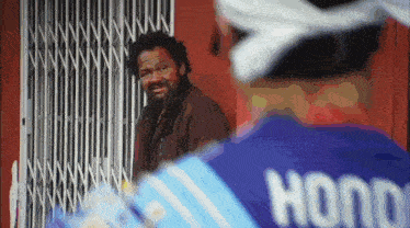 a man wearing a blue shirt that says hono on the back