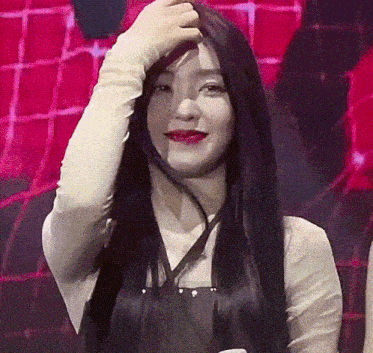 a woman with long black hair has her hand on her head