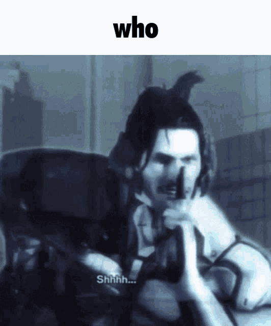 a man with a gun is making a shhh sign