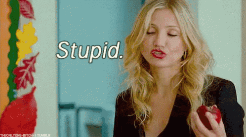a woman is holding a red apple with the words stupid behind her