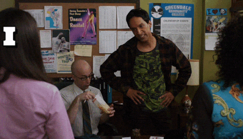 a man stands in front of a bulletin board that says greendale community college on it