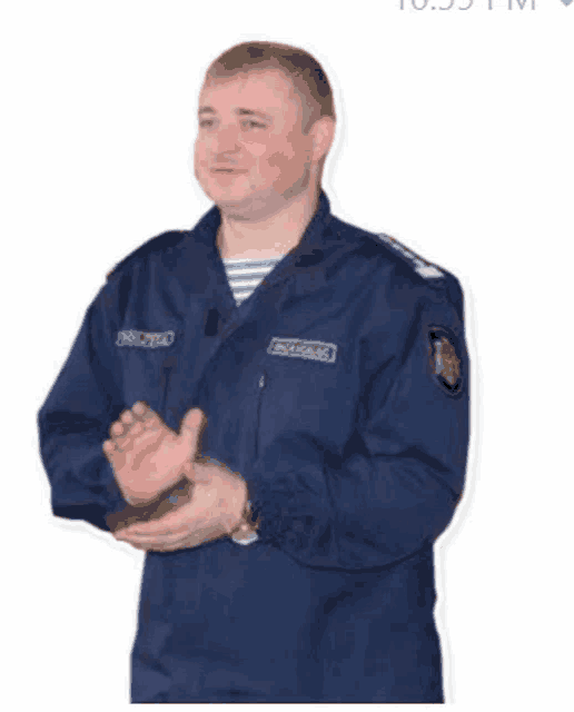 a man in a blue uniform is clapping his hands while standing on a white background .