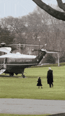 a united states of america helicopter is parked on a grassy field