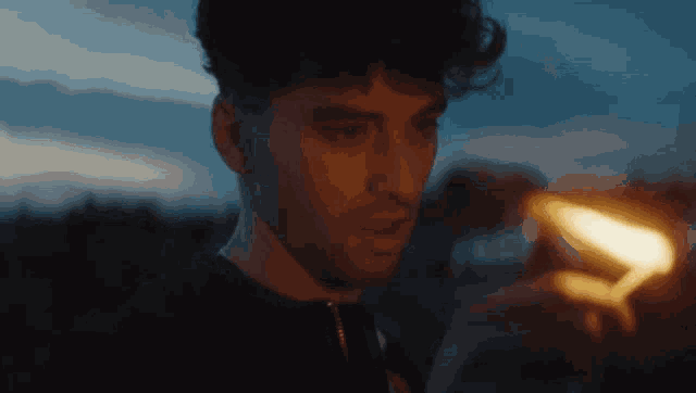 a close up of a man holding a lighter in his hand