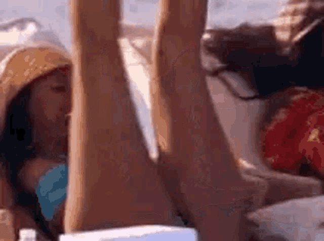 a woman in a bikini is laying on a couch with her legs in the air .