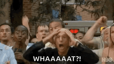a group of people are standing in a crowd with their hands on their heads and screaming .