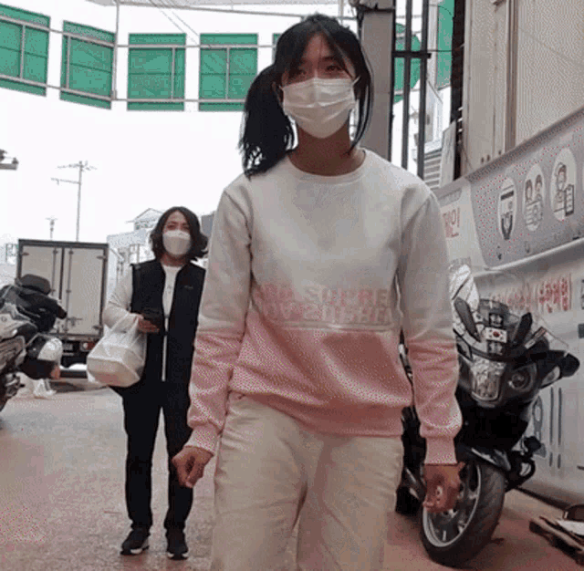 a woman wearing a face mask and a sweatshirt that says ' a shore way ' on it