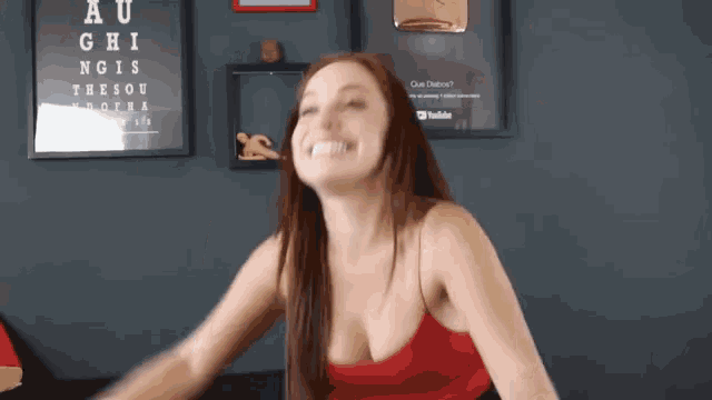 a woman in a red top is making a funny face in front of a sign that says au ghis
