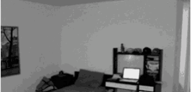 a man is standing in a room with a laptop