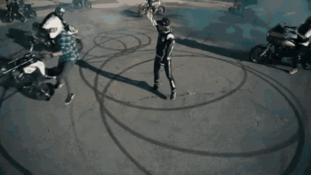 a group of motorcycle riders are doing tricks on the road