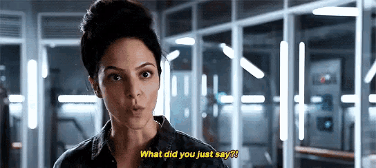 a woman is standing in a room and saying what did you just say .
