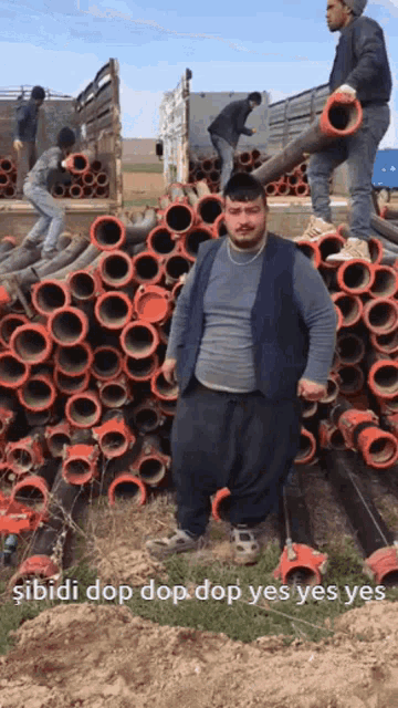 a man is standing in front of a pile of pipes with the words " sibidi dop dop dop yes yes yes " below him