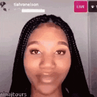a woman with braids is making a funny face in front of a live screen .