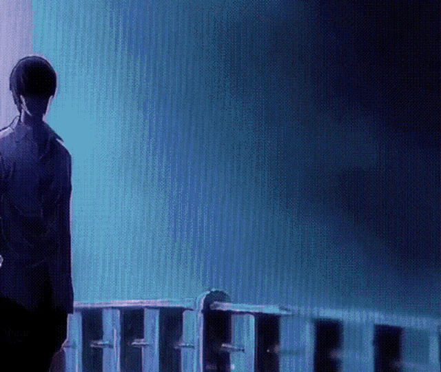 a person is standing in front of a blue wall and a fence