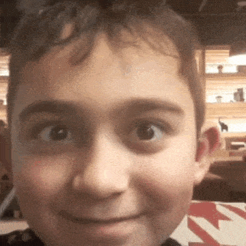 a close up of a boy 's face with a smile on his face .