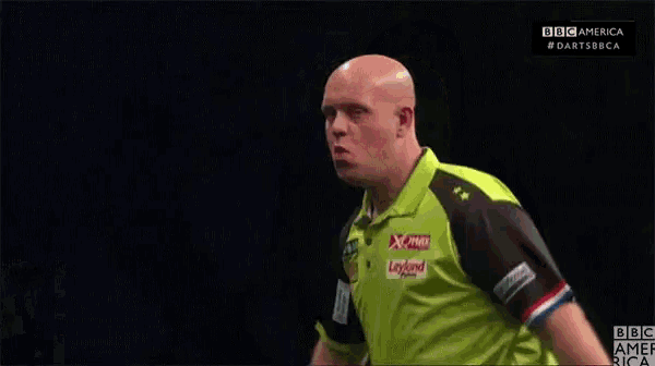 a bald man in a green shirt stands in front of a screen that says bbc america