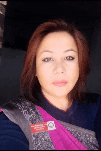 a woman wearing a pink and gray shawl with a tag that says ' nsd '
