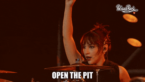 a woman playing a drum set with the words open the pit below her