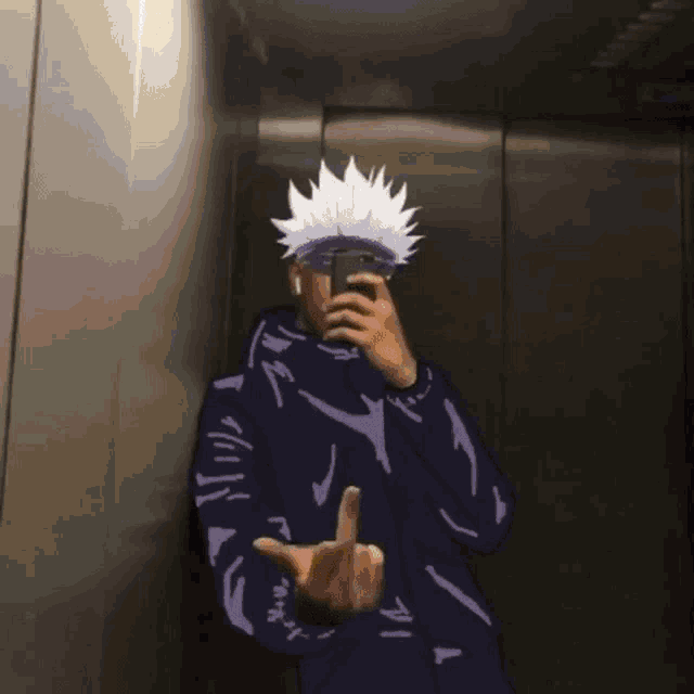 a man is taking a picture of himself in an elevator while holding a cell phone .