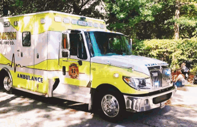 a white and yellow ambulance with the number 57 on the side