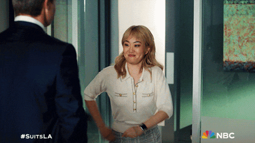 a woman in a white shirt is standing next to a man in a suit and the nbc logo can be seen in the corner