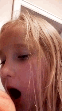 a close up of a blonde woman 's face with her mouth open