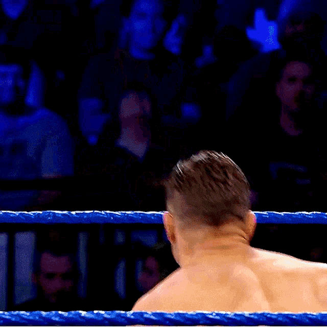 a man without a shirt is standing in a boxing ring