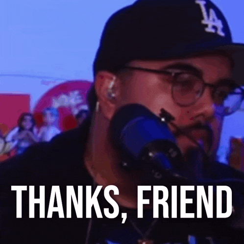 a man wearing a hat and glasses is standing in front of a microphone and says `` thanks , friend '' .