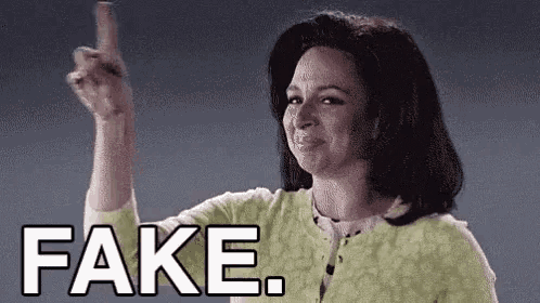 a woman in a green sweater is pointing her finger at the camera and saying `` fake '' .