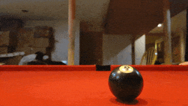 a pool table with a black ball with the number 8 on it
