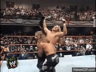 two men are wrestling in a wrestling ring .