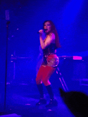 a woman singing into a microphone on stage