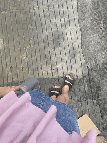 a person 's feet are shown on a concrete surface