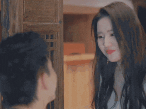 a man and woman are looking at each other and the woman is wearing red lipstick