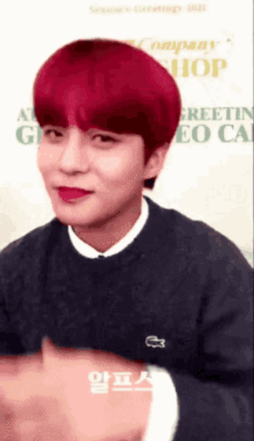a young man with red hair is wearing a sweater with a lacoste logo on it