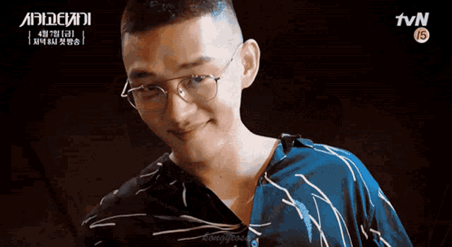 a close up of a man wearing glasses and a blue shirt with tvn in the corner