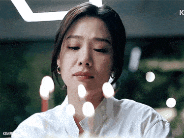 a close up of a woman 's face with the letter k on the bottom
