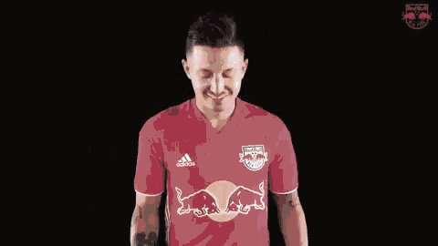 a man wearing a grey adidas jersey with a red bull logo on it