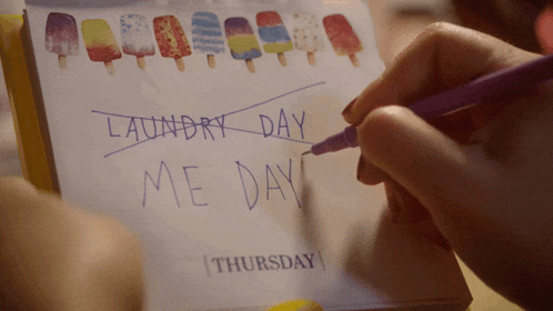 a person is writing on a piece of paper that says laundry day me day