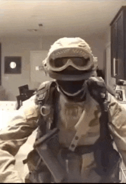 a man in a military uniform is wearing a helmet and goggles .