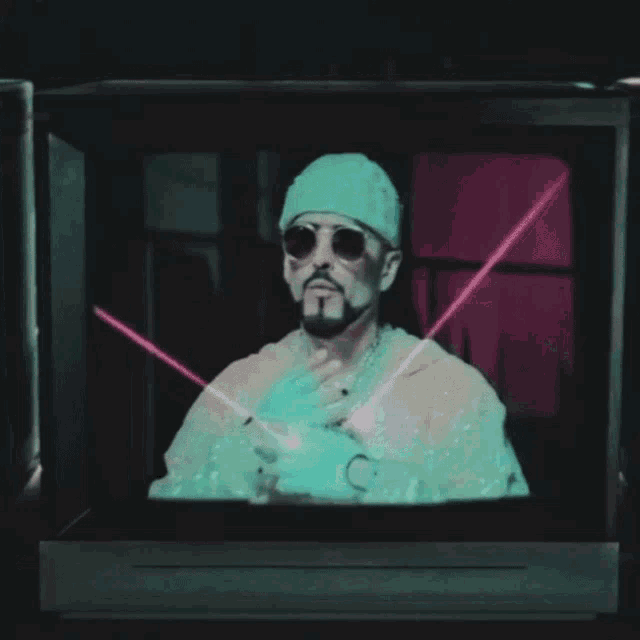 a man wearing sunglasses and gloves is making a peace sign on a tv screen